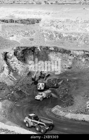 Immagine monocromatica dei lavoratori edili e dei veicoli in una cava Foto Stock