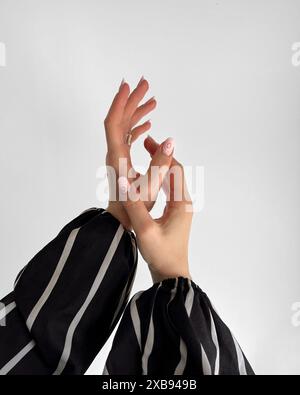 Una donna che alza le mani a dimostrazione delle unghie Foto Stock