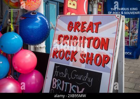 Un cartello per il Great Brighton Rock Shop e altri negozi di souvenir turistici sul lungomare di Brighton, East Sussex, Regno Unito Foto Stock