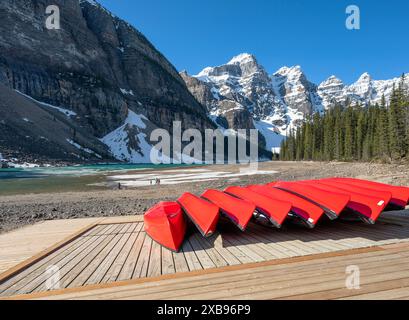 Canoe rosse sulla riva del lago Moraine nella Valle delle dieci cime nel Parco Nazionale di Banff, Alberta, Canada Foto Stock