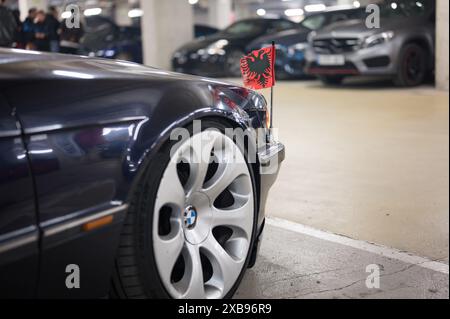 Auto tedesca BMW E38 di colore scuro con la bandiera dell'aquila imperiale tedesca sui parafanghi anteriori. Si tratta di un'aquila a due teste su sfondo rosso Foto Stock