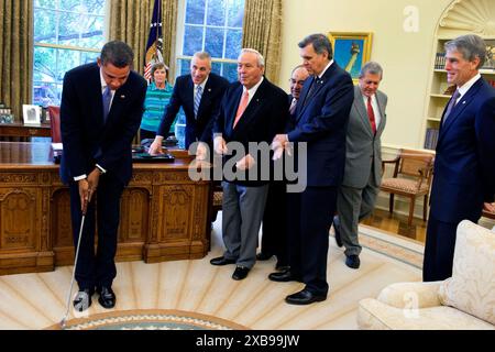 Il presidente Barack Obama prende un putt di pratica con un club di golf che gli viene presentato dalla leggenda del golf Arnold Palmer prima della cerimonia di firma per H.R. 1243, l'Arnold Palmer Congressional Gold Medal Act, nell'Ufficio ovale, 30 settembre 2009 Foto Stock