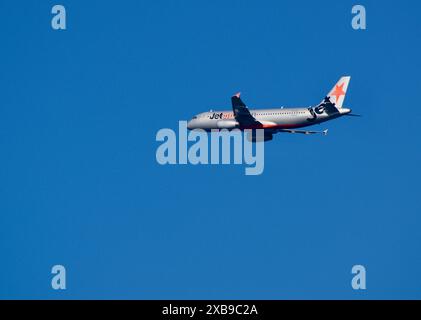 Un aereo della Jetstar Airways che vola contro un cielo azzurro limpido dopo il decollo dall'aeroporto di Wellington. Foto Stock