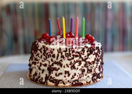 Torta della Foresta Nera con ciliegie, gocce di cioccolato e panna montata. Torta di compleanno con candele. Shvartsvald Cherry cake, una tradizionale pasticceria tedesca. Foto Stock