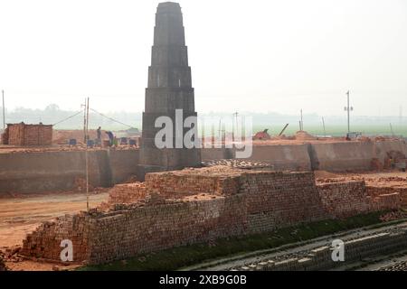 I mattoni di fango del suolo in un campo aperto sono lasciati asciugare al sole prima di essere bruciati nei forni tradizionali, il Bangladesh Foto Stock