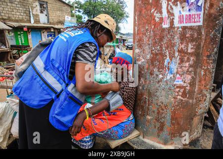 17 maggio 2024, Nairobi, Kenya: Un volontario sanitario della comunità (CHVs) di Plan International Kenya esegue test diagnostici gratuiti sull'ipertensione su un residente in occasione della giornata Mondiale dell'ipertensione. La giornata mondiale dell'ipertensione viene celebrata ogni anno per sensibilizzare sul rischio di ipertensione e sulle sue misure preventive. Oggi, il programma Young Health, un'iniziativa di sensibilizzazione NCD attuata da Plan International Kenya, ha segnato questa giornata conducendo attività porta a porta a Kibera da parte dei loro volontari sanitari della comunità (VSC) e dei medici. (Immagine di credito: © Donwilson Odhiambo/SOPA Imag Foto Stock