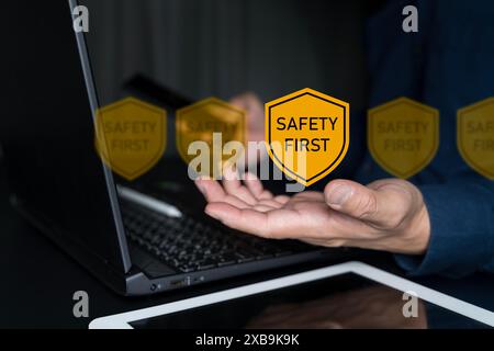 Concetto di sicurezza prima di tutto. Uomo d'affari che utilizza con simboli Safety First per la sicurezza sul lavoro, attenzione rischi sul lavoro, sorveglianza dei pericoli e zero incidenti. Foto Stock