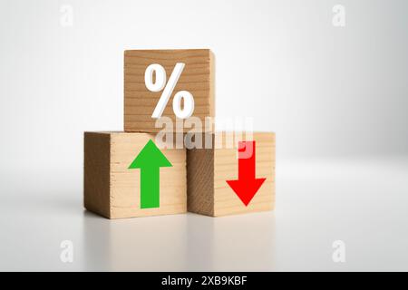 Blocchi di cubo di legno con simbolo di percentuale, icone con freccia verde su e freccia rossa giù. Concetto di tassi di interesse finanziari e ipotecari. Prestito m Foto Stock