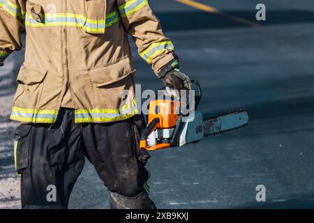 Vigile del fuoco con motosega in soccorso. Foto Stock