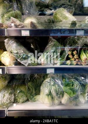 refrigeratore per supermercati con verdure in sacchetti di plastica Foto Stock