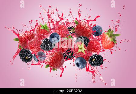 Frutti di bosco diversi e succo spruzzato su sfondo rosa Foto Stock