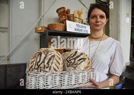 Leopoli, Ucraina. 8 giugno 2024. Una ragazza tiene in mano un cesto di pane, su cui è raffigurato lo stemma dell'Ucraina - Trident, alla Fiera dei prodotti biologici e artigianali di Leopoli. (Credit Image: © Pavlo Palamarchuk/SOPA Images via ZUMA Press Wire) SOLO PER USO EDITORIALE! Non per USO commerciale! Foto Stock