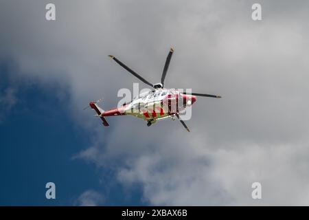 L'elicottero di ricerca e salvataggio della guardia costiera si prepara ad atterrare sulla cima della scogliera, Un drammatico salvataggio che coinvolge il servizio di Air Ambulance, le guardie costiere, RNLI Foto Stock