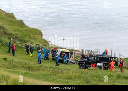 Si è svolto un soccorso drammatico che ha coinvolto il servizio di ambulanza aerea, le guardie costiere, la scialuppa di salvataggio costiera RNLI e l'elicottero di ricerca e salvataggio delle guardie costiere Foto Stock