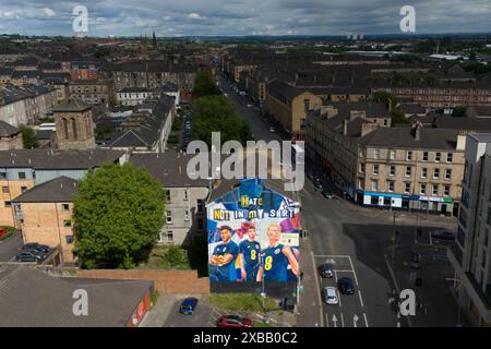 Un nuovo murale nell'estremità est di Glasgow con i giocatori scozzesi (da sinistra) che Adams, Andy Robertson e Scott McTominay, è stato svelato in vista della partita di apertura degli Euros contro la Germania di venerdì. Data foto: Martedì 11 giugno 2024. Foto Stock