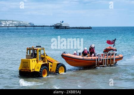 La scialuppa indipendente Sandown e Shanklin torna a terra e viene aiutata a sbarcare da un trattore che tira un rimorchio a cui è collegata la barca Foto Stock