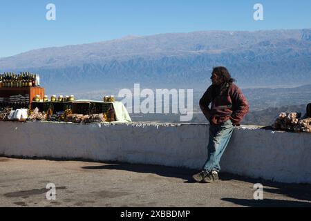 Salta. Argentina. uomo indigeno locale, venditore ambulante, che vende cibo fatto in casa fuori su una strada per passare gli autobus turistici Foto Stock