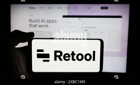 Persona che detiene un cellulare con il logo della società di sviluppo software statunitense Retool Inc. Di fronte alla pagina Web aziendale. Mettere a fuoco il display del telefono. Foto Stock