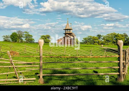 Il paesaggio del campo, il giardino e la vecchia cappella in legno dell'Arcangelo Mikhail del XV secolo sull'isola di Kizhi Foto Stock