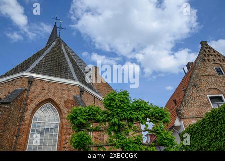 Chiesa in mattoni rossi con architettura gotica e alte torri, qualcuno in un villaggio con bel tempo, Bredevoort, gelderlande, paesi bassi Foto Stock