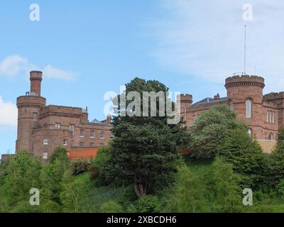 Un grande castello su una collina verde, circondato da alberi e sotto un cielo blu, inverness, scozia, Gran Bretagna Foto Stock