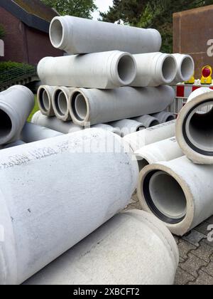Numerosi tubi in calcestruzzo impilati immagazzinati lungo la strada tubi in calcestruzzo per la costruzione di fognature posa di fognature durante la costruzione di strade, Germania Foto Stock
