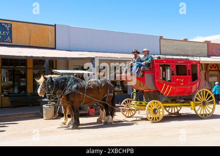 Carrozza trainata da cavalli su strade sterrate fiancheggiate da vecchie vetrine occidentali in stile territoriale a Tombstone in Arizona - aprile 2024 Foto Stock