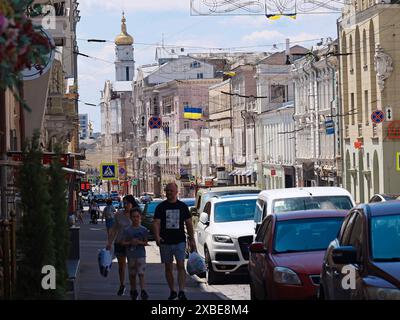 Non esclusiva: CHARKIV, UCRAINA - 8 GIUGNO 2024 - le persone passano accanto alle auto parcheggiate sul ciglio della strada, Charkiv, Ucraina nord-orientale. Foto Stock