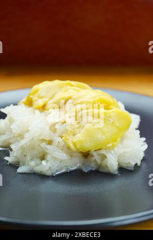 Piatto di dessert tailandese popolare di riso appiccicoso con latte di noce di cocco e duriano chiamato Kao Niaow Turian Foto Stock