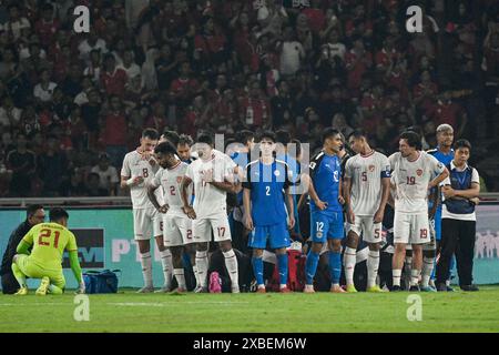 Giacarta, Indonesia. 11 giugno 2024. I giocatori fanno un cerchio mentre il personale medico curano Adrian Ugelvik delle Filippine durante la partita del gruppo F delle qualificazioni asiatiche ai Mondiali FIFA 2026 tra Indonesia e Filippine a Giacarta, Indonesia, 11 giugno 2024. Crediti: Agung Kuncahya B./Xinhua/Alamy Live News Foto Stock