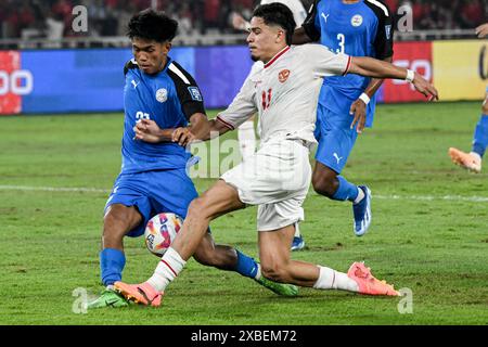 Giacarta, Indonesia. 11 giugno 2024. Ragnar Oratmangoen (R) indonesiano partecipa al pallone durante la partita del gruppo F delle qualificazioni asiatiche ai Mondiali FIFA 2026 tra Indonesia e Filippine a Giacarta, Indonesia, 11 giugno 2024. Crediti: Agung Kuncahya B./Xinhua/Alamy Live News Foto Stock