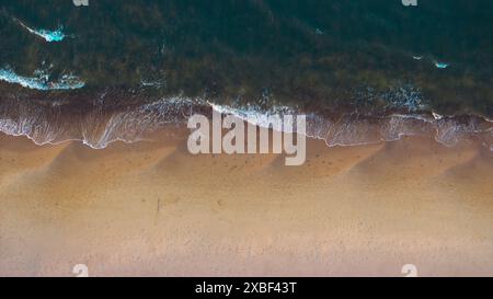 Vista aerea: Spiaggia isolata, onde marine tranquille. Foto Stock