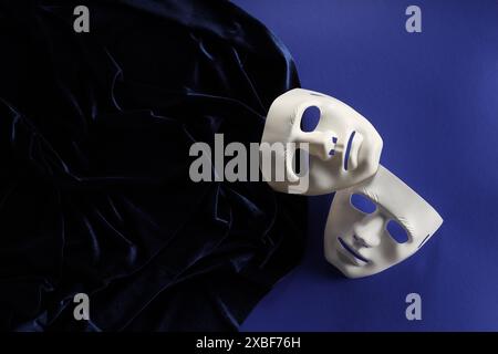 Arti teatrali Maschere bianche e tessuto su sfondo blu, vista dall'alto Foto Stock