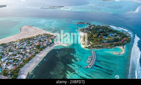 Una vista aerea di un'isola tropicale con acque turchesi cristalline e bungalow sull'acqua nelle Maldive Foto Stock