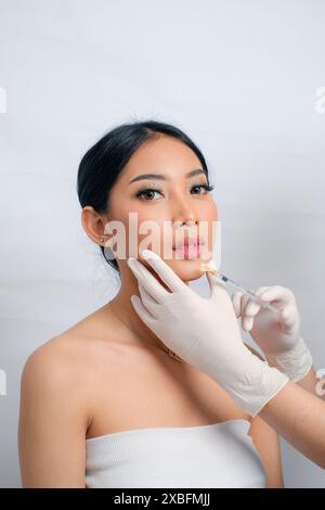 Bellezza donna asiatica con Updo ricevente Filler Injection Foto Stock