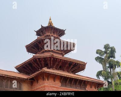 Un tempio tradizionale in stile pagoda in Nepal con intricate incisioni in legno sotto un cielo limpido. Foto Stock