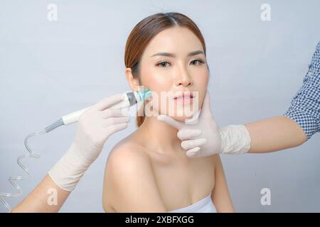 Bella donna asiatica sottoposta a trattamento facciale SilkPeel Foto Stock