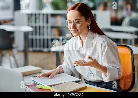 Una tutor femminile con la testa rossa si è impegnata in una sessione di insegnamento online mentre utilizzava un laptop per le lezioni dopo la scuola. Foto Stock