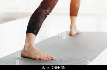 Donna gambe in piedi su Yoga Mat primo piano Foto Stock