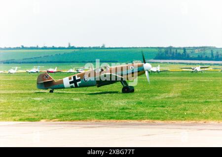 Messerschmitt Bf-109G-2/Trop Luftwaffe aereo da caccia della seconda guerra mondiale G-USTV - Black 6 - che ha preso il volo al Duxford Airshow nel 1996. Costruito nel settembre 1942 e servito con il JG77 in Italia e Nord Africa come "Black 6". Scoperto abbandonato dagli Alleati in avanzata all'inizio di novembre 1942 e portato nel Regno Unito. Operato da 1426 Enemy Aircraft Flight con base a RAF Collyweston per prove di combattimento contro tipi alleati. Dopo un lungo periodo di stoccaggio e un prolungato restauro è stato reso aeronavigabile nel marzo 1991. Volò raramente fino a quando non fu danneggiato quando si schiantò sul campo vicino alla M11 a Duxford nell'ottobre 1997 Foto Stock