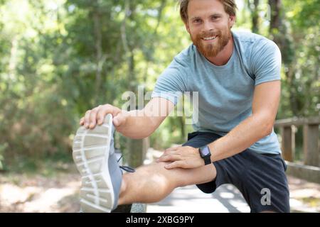 L uomo si allunga la gamba in terra spazio per il testo Foto Stock