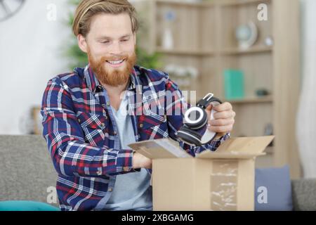 uomo barbuto che riceve le earhpnes in pacco Foto Stock