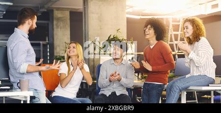 Diversi gruppi di colleghi applaudono durante una riunione di gruppo Foto Stock