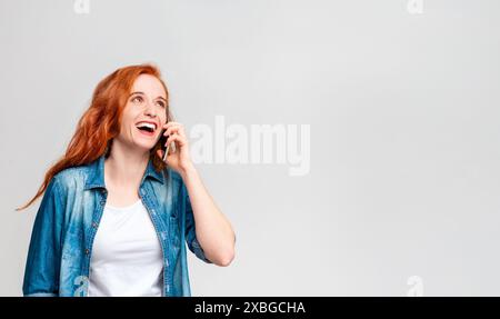 Donna con capelli rossi che parla al telefono Foto Stock