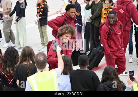 Stoccarda, Germania. 12 giugno 2024. Calcio: Campionato europeo, gruppo D, Belgio, arrivo in aeroporto: Il calciatore belga Wout Faes firma autografi mentre lascia l'aereo. Crediti: Bernd Weißbrod/dpa/Alamy Live News Foto Stock