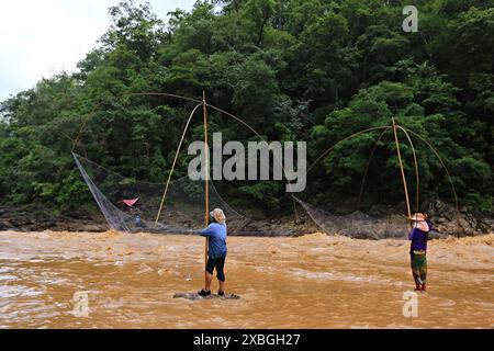 Pescatori che utilizzano attrezzature per la pesca a rete (rete quadrata) per la cattura di pesci a Kaeng Luang, provincia di Nan, Thailandia Foto Stock