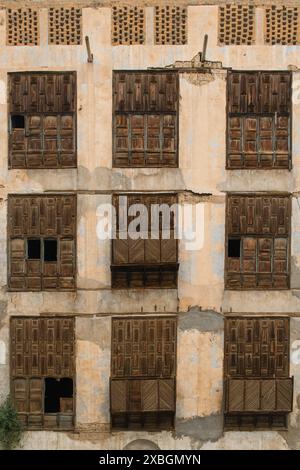 Jeddah, Arabia Saudita - 12 dicembre 2022: Una vista dettagliata delle finestre a reticolo in legno di un edificio storico nel quartiere di al-Balad, che illustrano la t Foto Stock