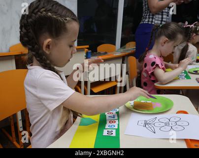 CHARKIV, UCRAINA - 9 GIUGNO 2024 - Una ragazza studia figure in un centro di assistenza diurna nella metropolitana di Charkiv, Charkiv, Ucraina nord-orientale. Foto Stock