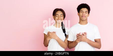 Tipo di cuore ragazzi tenendo le mani compresi sul petto Foto Stock