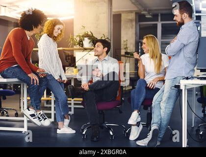 Incontro informale con giovani professionisti che discutono di idee di progetto Foto Stock